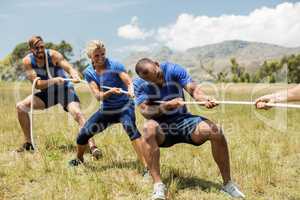 People playing tug of war during obstacle training course