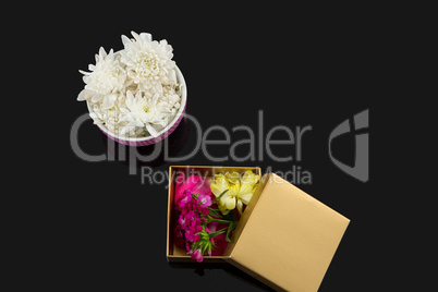 Opened gift box and bowl with flowers