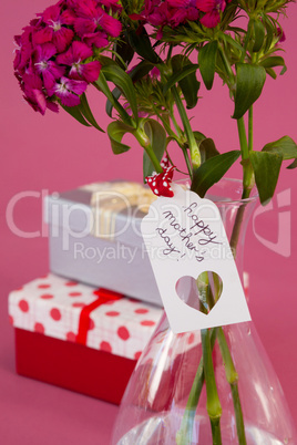 Close-up of happy mothers day card on flowers vase