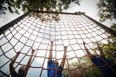 People climbing a net during obstacle course