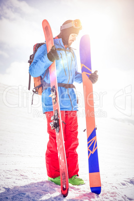 Skier holding ski on snowy mountains