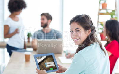 Composite image of smiling businesswoman using tablet
