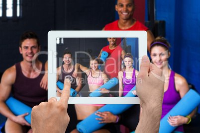 Composite image of hand holding tablet pc