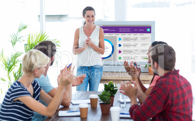 Composite image of colleagues clapping hands in a meeting