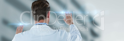 Composite image of rear view of doctor touching transparent interface