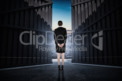 Composite image of young businesswoman standing with hands behind back 3d