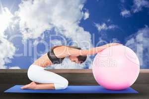 Composite image of side view of a fit woman exercising with fitness ball