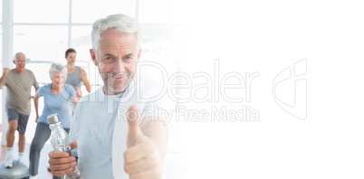 Man showing thumbs up sign with people exercising in background