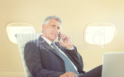 Composite image of businessman having a phone call