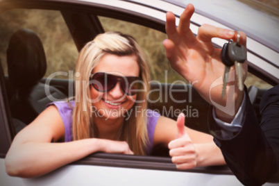 Composite image of happy seller holding car keys
