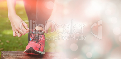 Young woman tying the shoelaces of her running shoes