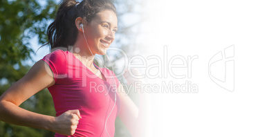 Cheerful young woman jogging in a park