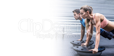 Muscular couple doing bosu ball exercises