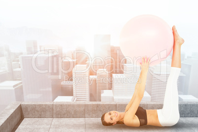 Composite image of side view of a fit woman exercising with fitness ball