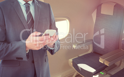 Composite image of smiling businessman using mobile phone