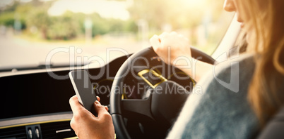 Cropped image of woman using smart phone while driving