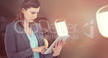 Composite image of businesswoman working on digital tablet