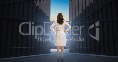 Composite image of businesswoman standing back to camera 3d