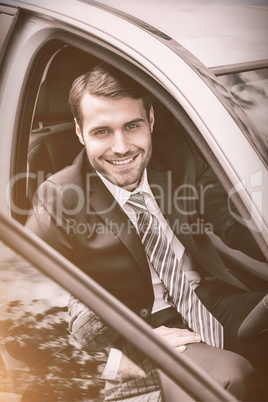 Smiling businessman sitting in drivers seat