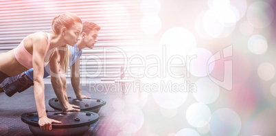 Muscular couple doing bosu ball exercises