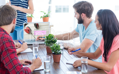 Composite image of business team using a laptop
