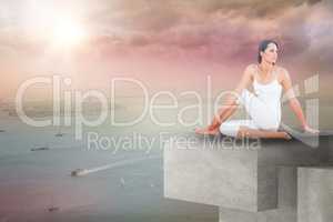 Composite image of fit woman doing the half spinal twist pose in fitness studio