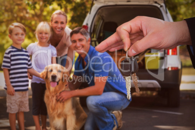 Composite image of happy woman receiving car keys