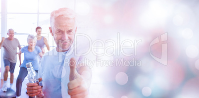 Man showing thumbs up sign with people exercising in background