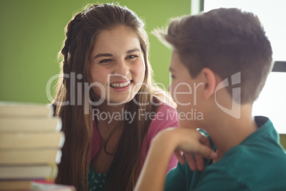 Smiling school kids interacting in library