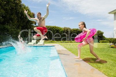 Happy father and daughter jumping in swimming pool