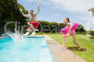 Happy father and daughter jumping in swimming pool