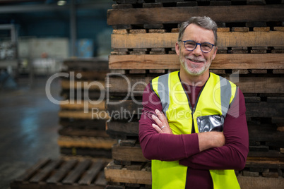 Portrait of male factory worker standing with arms crossed