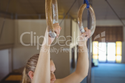 Female gymnast practicing gymnastics on rings