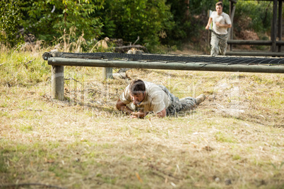 Soldier crawling under the net during obstacle course