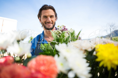 Smiling florist holding bunch of flower in florist shop