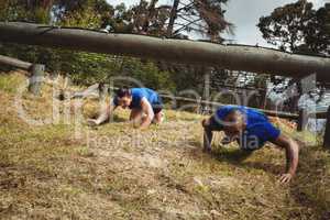 Fit people crawling under the net during obstacle course