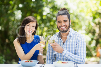 Couple toasting glasses of wine in a restaurant