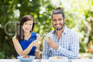 Couple toasting glasses of wine in a restaurant