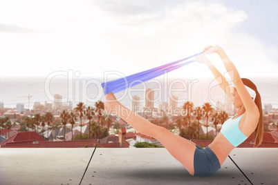 Composite image of fit young woman exercising with a blue yoga belt