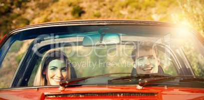Portrait of smiling couple in red cabriolet