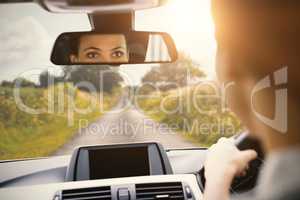 Woman driving with her reflection in the mirror