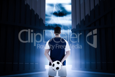 Composite image of rear view of sportsman holding football at his back 3d