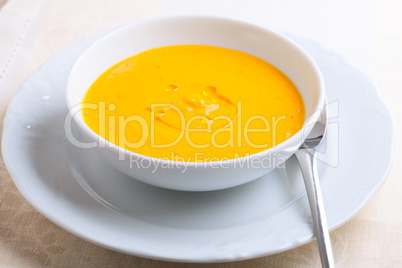 Pumpkin soup with cream served on a table