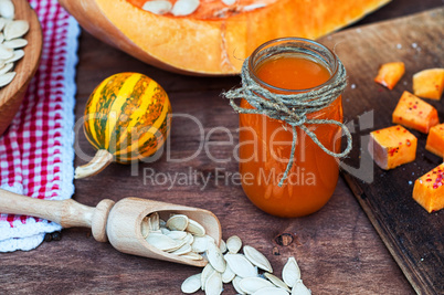 Pumpkin juice in a glass jar with raw seeds in the shell