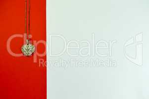 Heart-shaped pendant on a red strip on a white background
