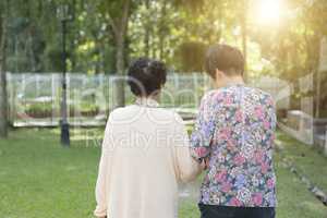 Rear view Asian elderly women walking in outdoor park