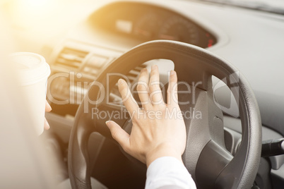 Human hand on steering and honking