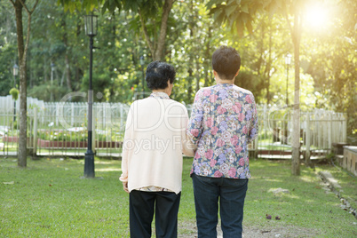 Rear view Asian elderly women walking in garden park