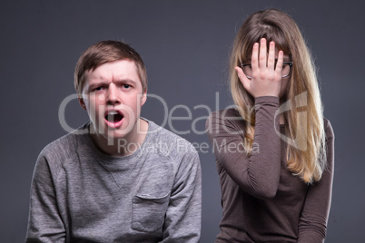 Portrait of facepalm teenage couple