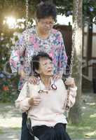 Asian elderly women playing swing at outdoor playground